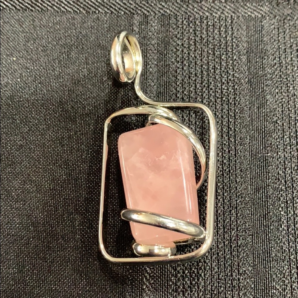 Silver toned pendant with pink stone in the middle